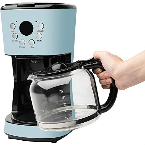 Blue coffee maker with a hand holding a glass coffee pot.