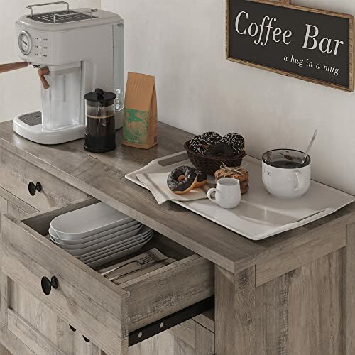 Coffee bar setup with coffee maker, mugs, donuts, and plates.