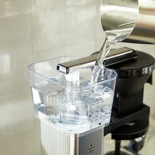 Water being poured into a coffee maker reservoir