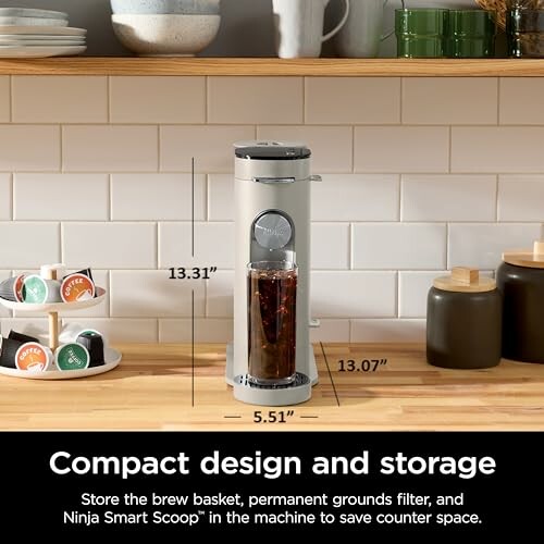 Compact coffee maker on counter with dimensions labeled.