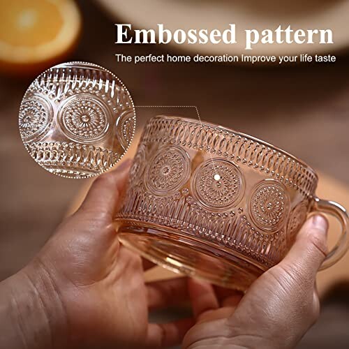 Hands holding an embossed glass cup with intricate patterns.