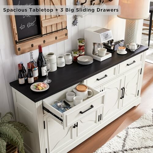 White kitchen buffet cabinet with black countertop, sliding drawers, and various kitchen items including a coffee maker.