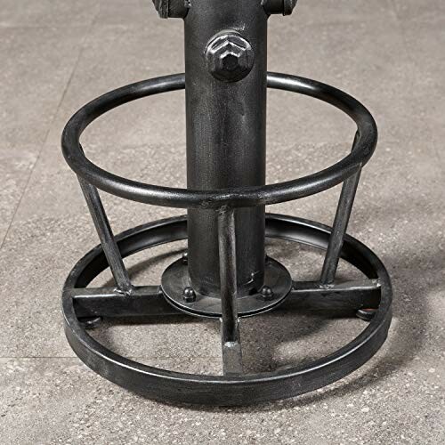 Metal base of a bar stool with circular footrest.