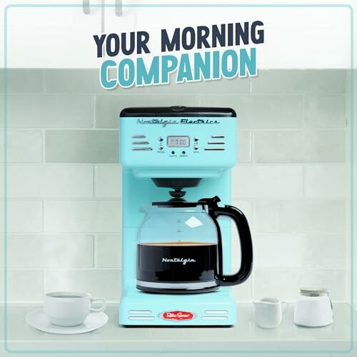 Retro-style blue coffee maker with a pot of coffee, mug, and cream on a kitchen counter.