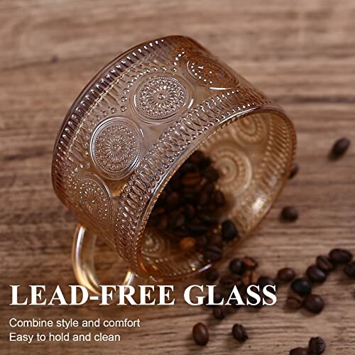 Vintage glass mug with intricate design, coffee beans inside, on wooden surface.